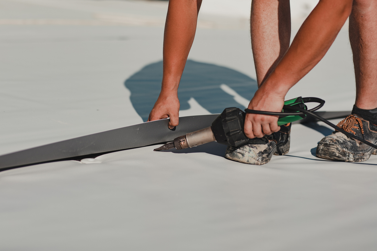 Worker welding PVC roof membrane