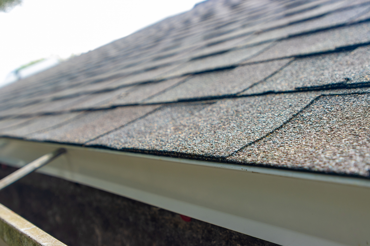 Brand new asphalt roof shingles protect a house from rain.