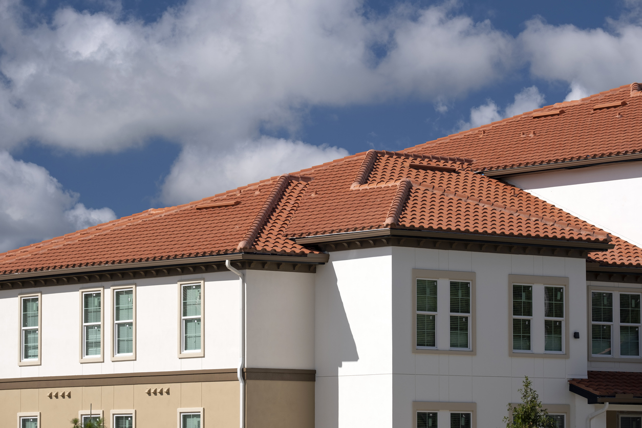 Tiled roof covering of condo building in Florida. Closeup of house rooftop covered with ceramic shingles.