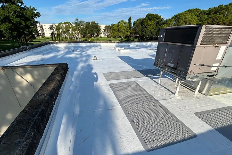 White TPO membrane roof with rooftop HVAC equipment on a commercial building