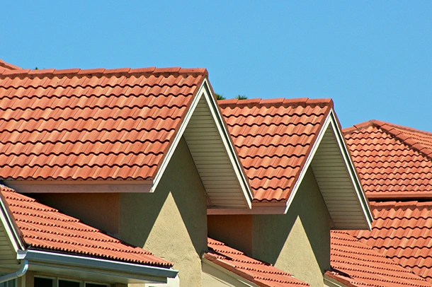 Clay tile roof gables on a Florida home under a clear blue sky