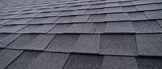 Close-up of dark gray asphalt shingles across a residential roof slope