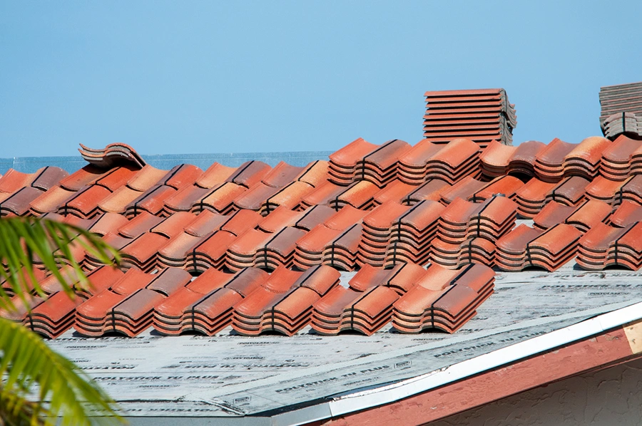 Stacks of new clay roof tiles staged across a roof before installation
