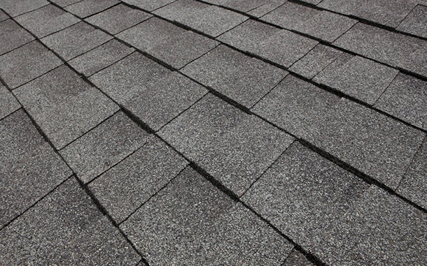 Close-up of dark gray architectural asphalt shingles on a roof slope