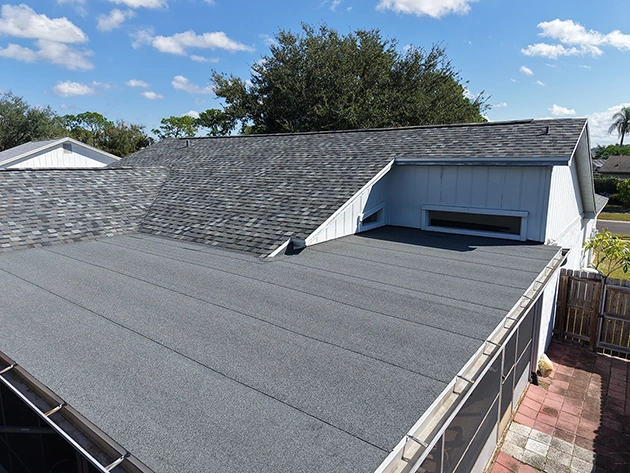 Modified bitumen flat roof section joining a shingle roof on a Florida home