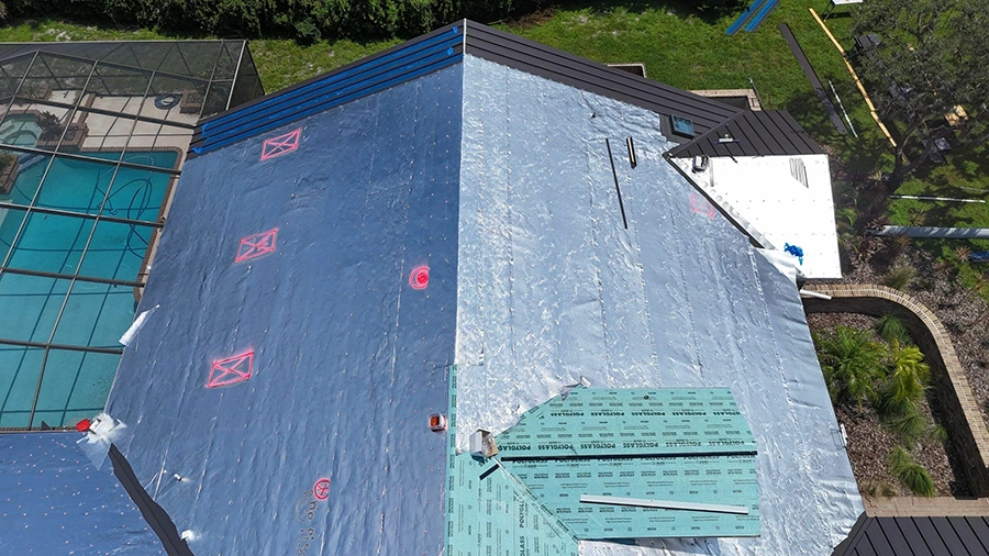 Low-E ThermaSheet insulated underlayment being installed on a roof deck