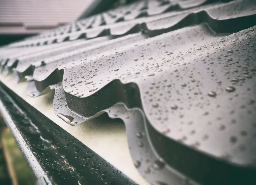 Water droplets beading on a corrugated metal roof panel
