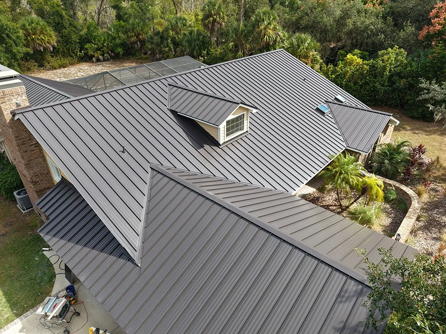 Aerial view of a dark bronze standing seam metal roof installation on a Florida home