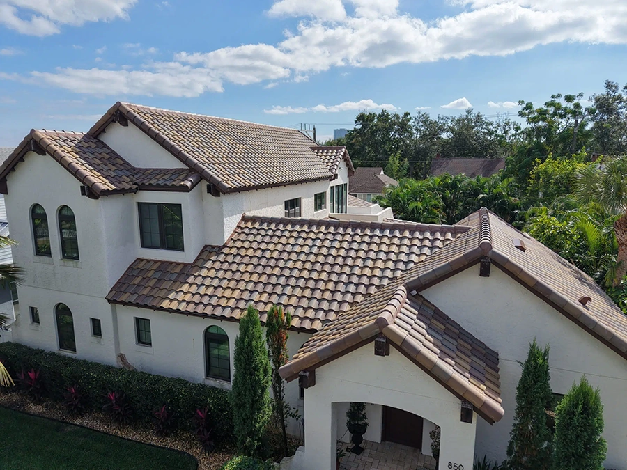 Barrel tile roof installation on a white stucco Florida home with blended clay tiles