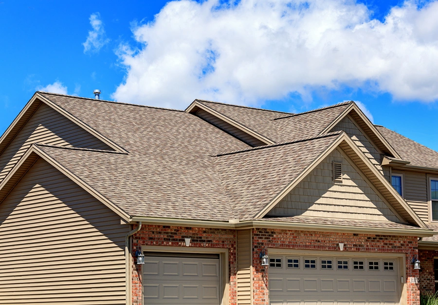 Architectural shingle roof with multiple gables on a brick and siding home