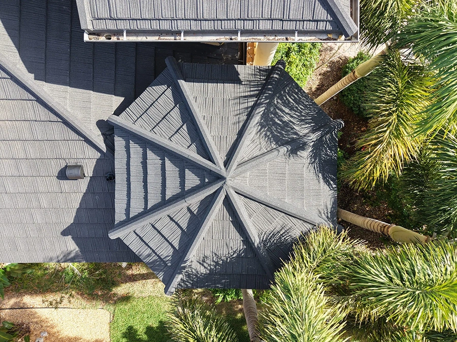 Overhead view of a dark stone-coated steel roof installation on a Florida home