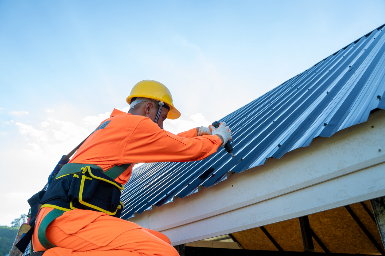 Professional technical workers working install new roof,Roofing tools,Electric drill used on new roofs with Metal Sheet.