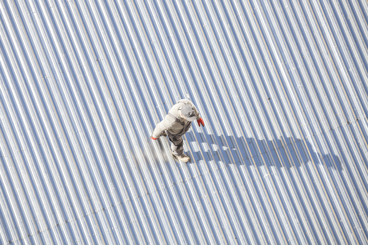 Man inspecting a roof after repair.