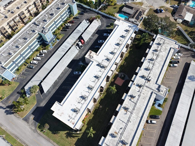 Aerial view of white flat roof systems installed across a Florida multi-building property